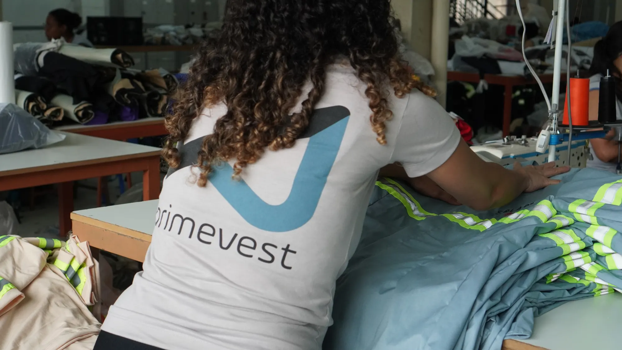 Costureira da Primevest montando uniforme com faixa refletiva